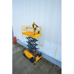 Haulotte COMPACT 12 DX i bruk ute foran en hvit vegg