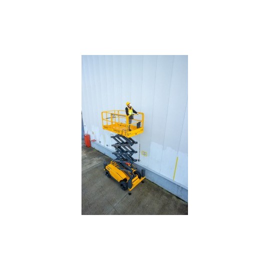 Haulotte COMPACT 12 DX i bruk ute foran en hvit vegg
