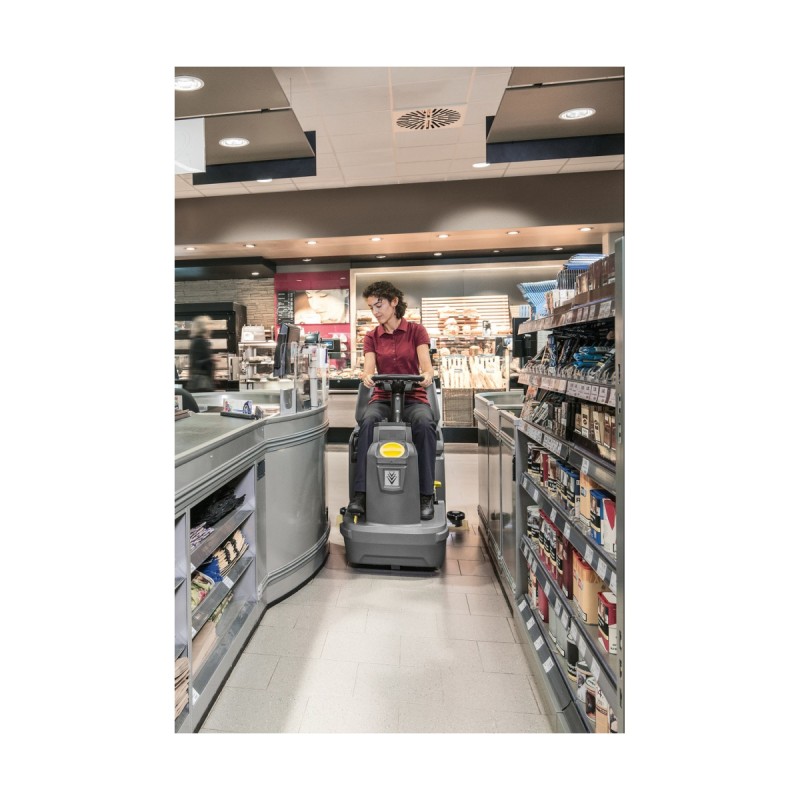 Sitte-på gulvvaskemaskin fra Kärcher, mellom trange reoler i dagligvarebutikk